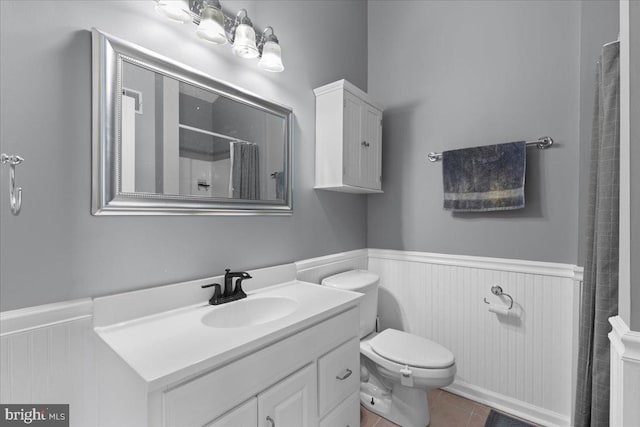 bathroom with walk in shower, vanity, tile patterned flooring, and toilet