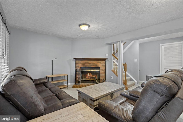 living room featuring a textured ceiling and a brick fireplace