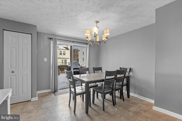 dining area featuring a textured ceiling and a chandelier