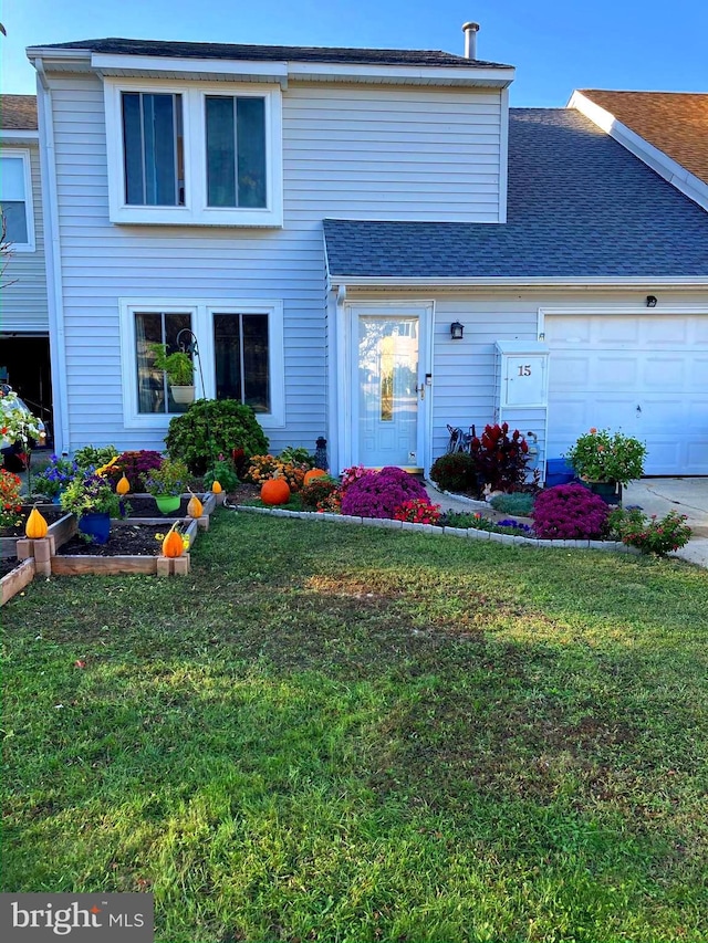 view of property featuring a front yard and a garage