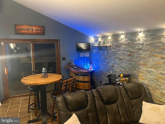 bar featuring tile patterned floors and vaulted ceiling