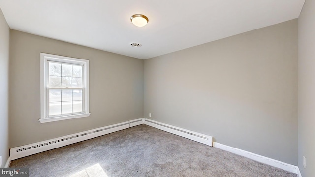 empty room featuring a baseboard heating unit and carpet flooring