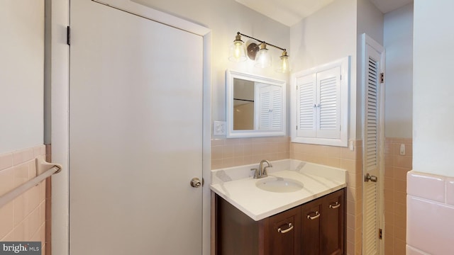 bathroom featuring vanity and tile walls