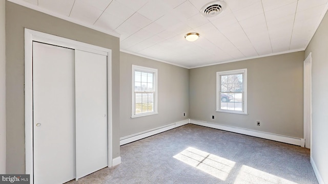 unfurnished bedroom with carpet, baseboard heating, crown molding, and multiple windows