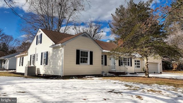 view of front facade with a garage and central air condition unit