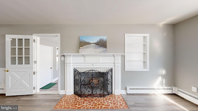 living room with a baseboard heating unit, built in features, and wood-type flooring