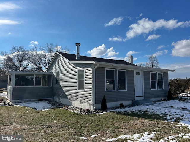 view of front of home with a sunroom and a yard