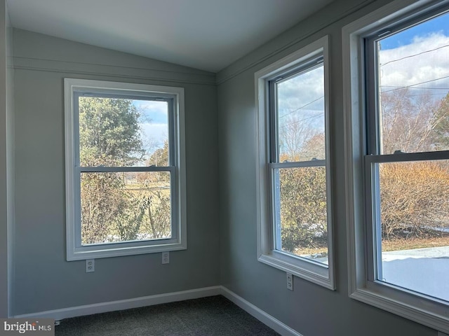 spare room with vaulted ceiling and carpet