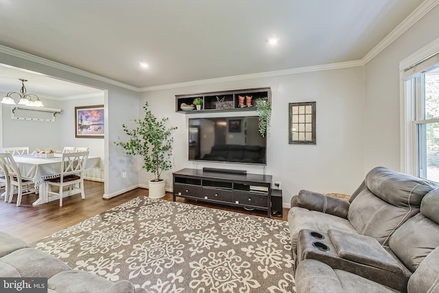 living room featuring wood-type flooring, a notable chandelier, and ornamental molding