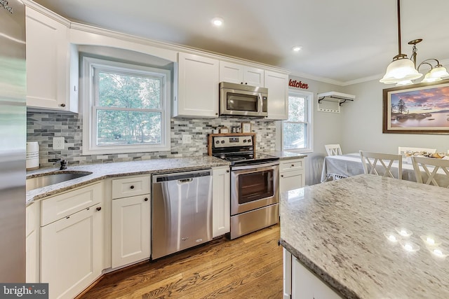 kitchen with pendant lighting, white cabinetry, and stainless steel appliances