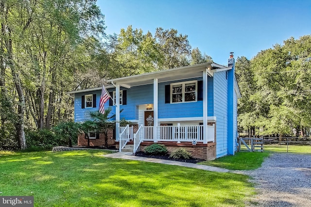 split foyer home featuring covered porch and a front lawn