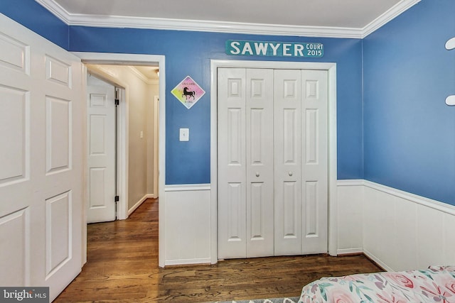 bedroom featuring dark hardwood / wood-style floors, a closet, and crown molding