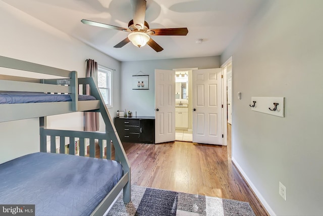 bedroom with ceiling fan, sink, hardwood / wood-style floors, and ensuite bath