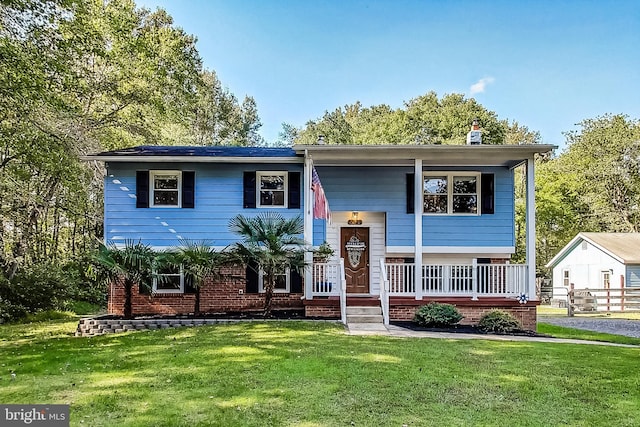 bi-level home with covered porch and a front yard