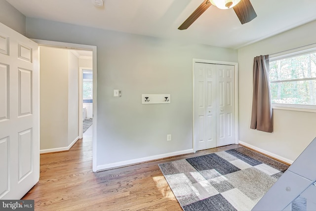 interior space featuring ceiling fan, a closet, and light wood-type flooring