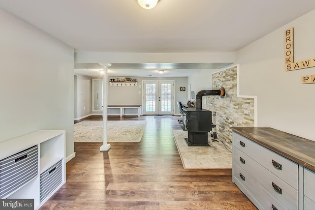 interior space featuring french doors, dark wood-type flooring, and a wood stove