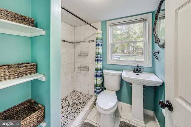 bathroom featuring toilet, a shower with curtain, and tile patterned flooring