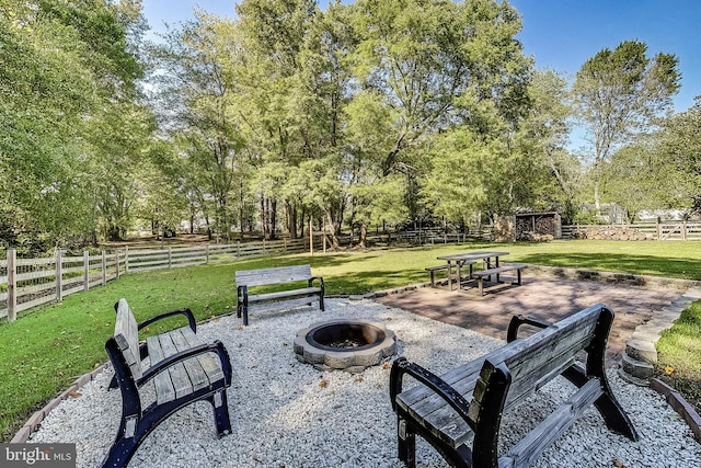 surrounding community featuring a yard, a fire pit, and a patio