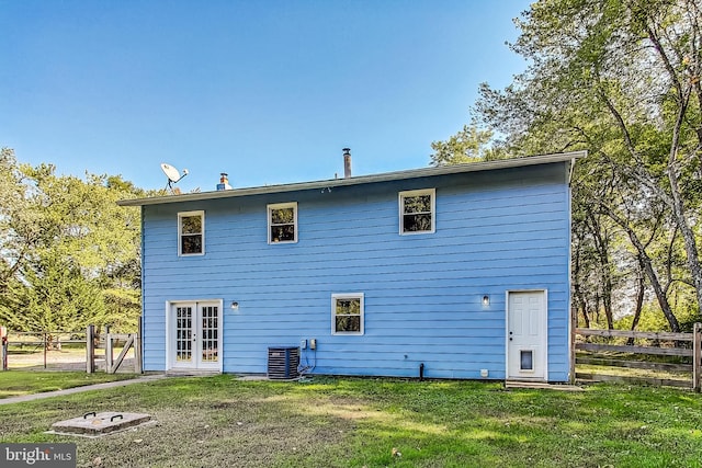 back of house featuring cooling unit, french doors, and a yard