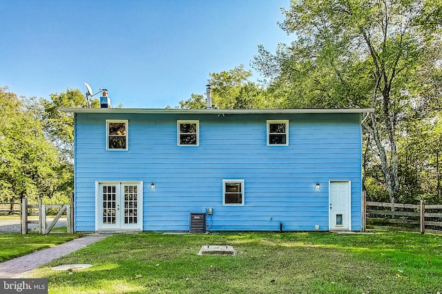 rear view of property featuring central air condition unit, french doors, and a yard