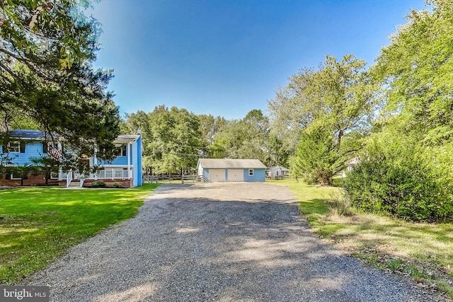 view of front of property featuring an outbuilding, a front yard, and a garage