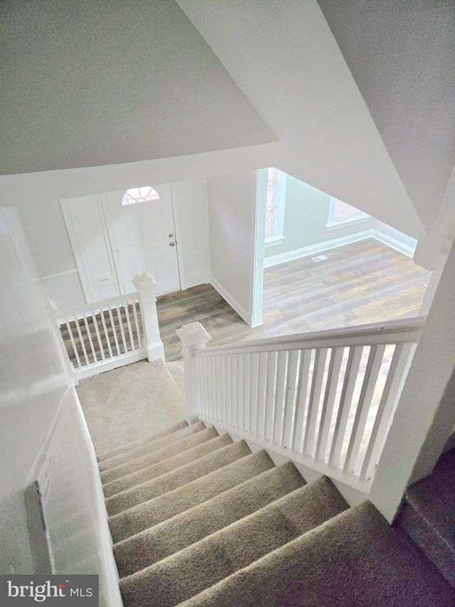 stairway featuring lofted ceiling