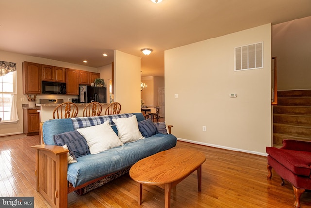 living room with light hardwood / wood-style flooring and a chandelier