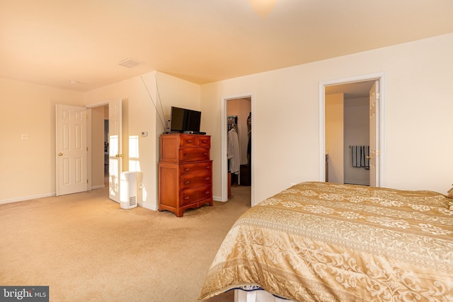 carpeted bedroom with a spacious closet and a closet