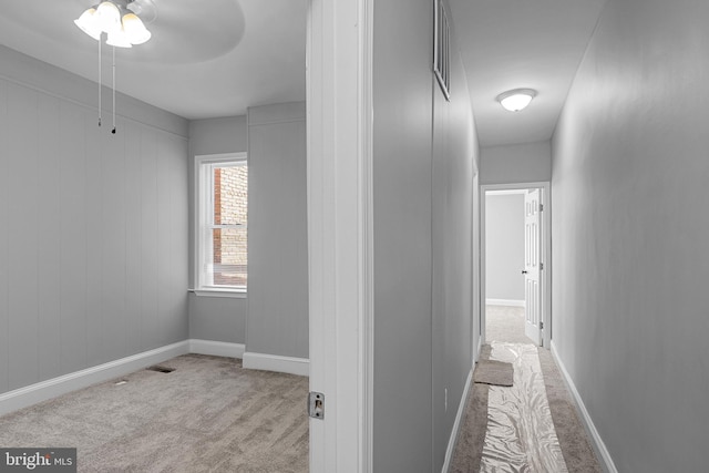 corridor featuring light colored carpet