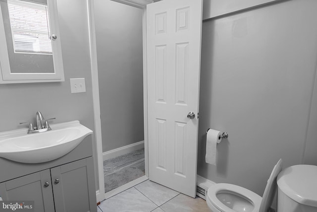 bathroom with toilet, vanity, and tile patterned flooring