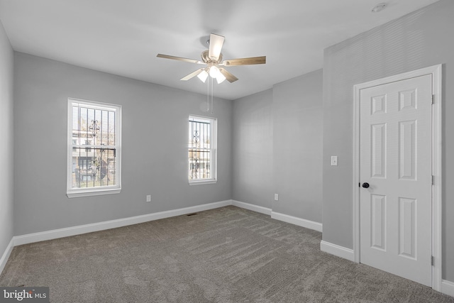 carpeted spare room with ceiling fan