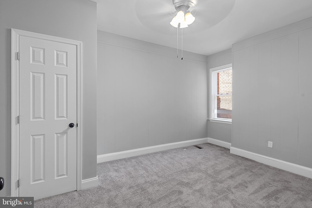 carpeted spare room featuring ceiling fan