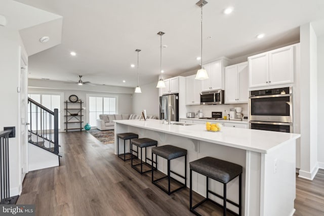 14079 Sunrise Valley Dr Unit 15P, Herndon, VA 20171 - kitchen with appliances with stainless steel finishes, a large island, a ceiling fan, white cabinets, and dark wood finished floors