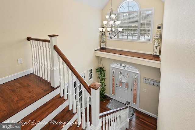 stairway with a chandelier and wood-type flooring