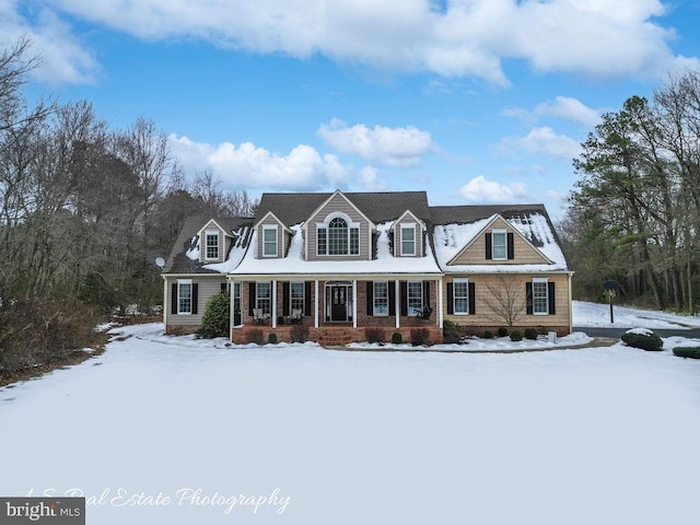 cape cod home featuring covered porch