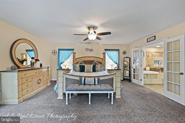 carpeted bedroom with a textured ceiling, ceiling fan, french doors, and ensuite bath