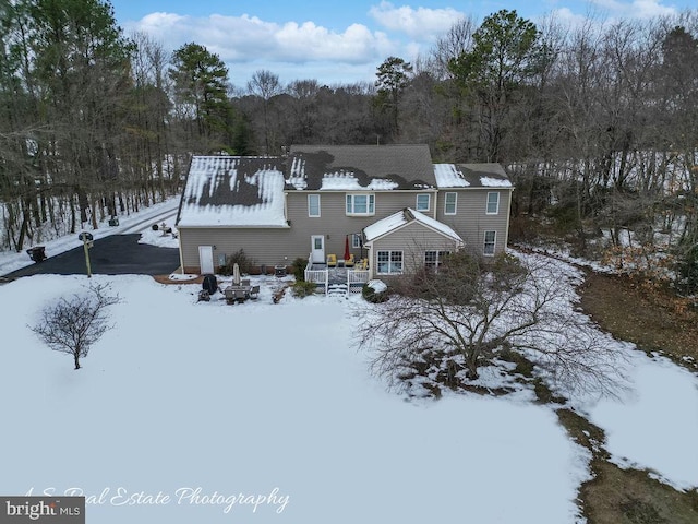 view of snow covered rear of property