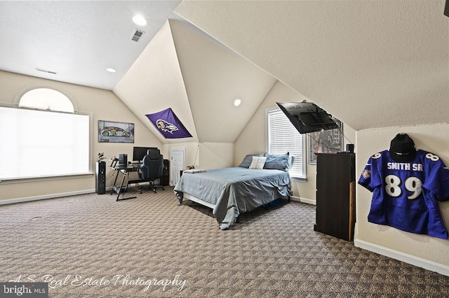 bedroom featuring vaulted ceiling, a textured ceiling, and carpet flooring