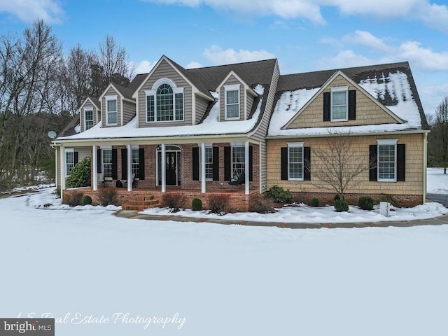 cape cod home featuring covered porch