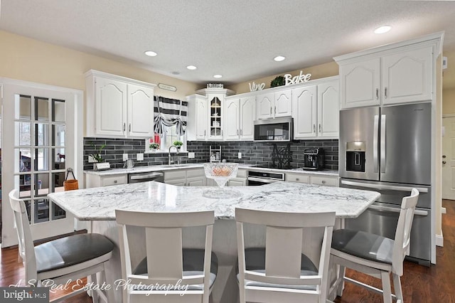 kitchen featuring a kitchen breakfast bar, white cabinetry, a center island, and stainless steel appliances