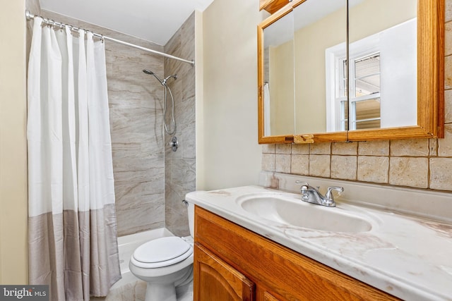 full bath with backsplash, tiled shower, vanity, and toilet