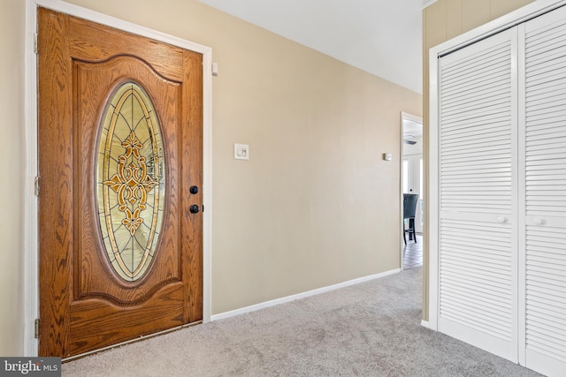 entryway featuring light carpet and baseboards