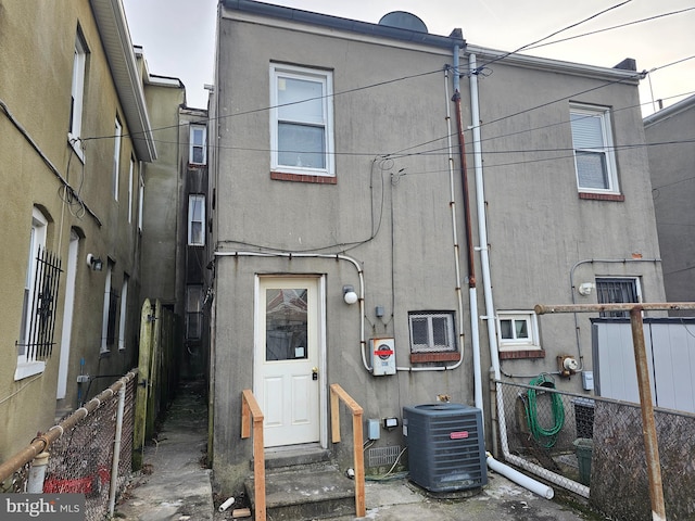 back of house with central AC unit