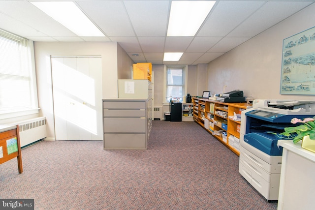 carpeted home office featuring a healthy amount of sunlight, a drop ceiling, and radiator heating unit