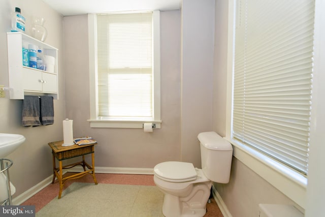 bathroom featuring plenty of natural light and toilet