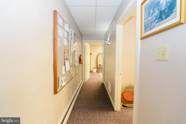 corridor featuring a paneled ceiling and carpet