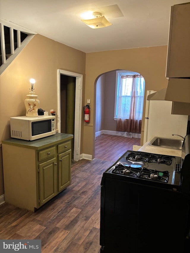 kitchen featuring green cabinetry, black gas range oven, dark hardwood / wood-style floors, and sink