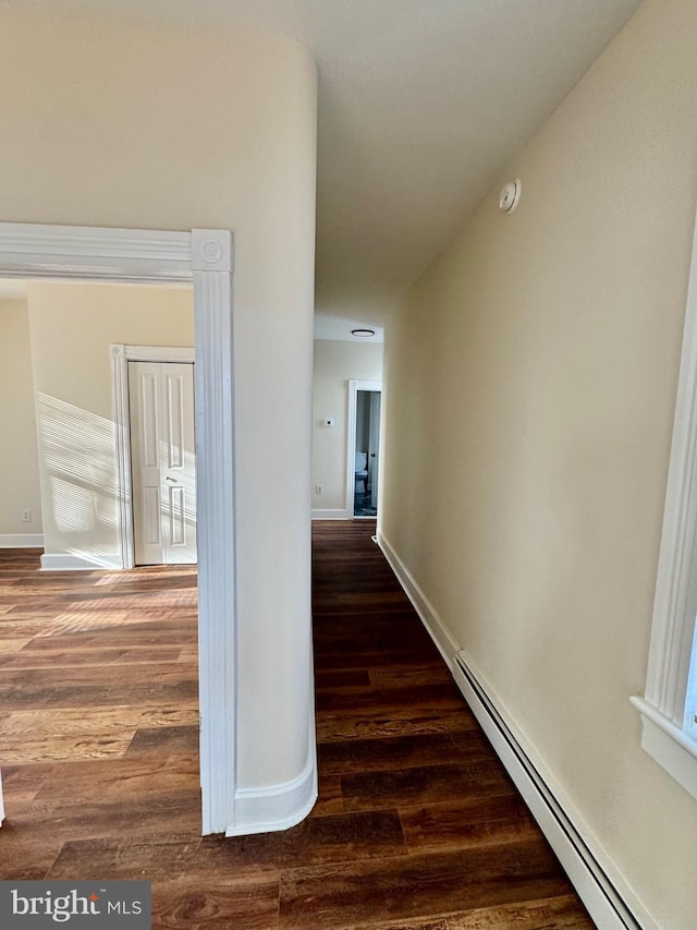 hall featuring baseboard heating and dark hardwood / wood-style floors