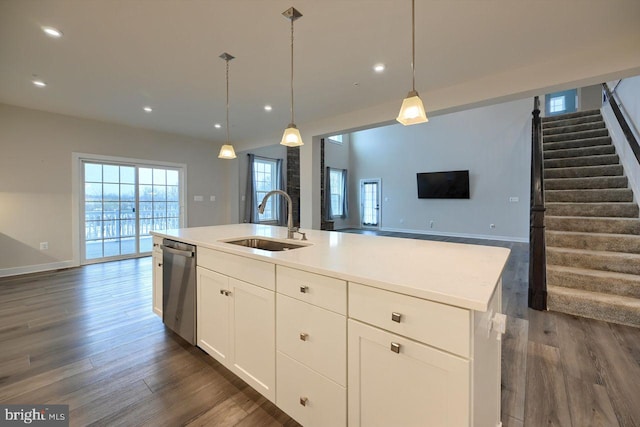 kitchen with dishwasher, pendant lighting, sink, white cabinetry, and an island with sink