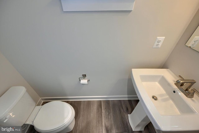 bathroom featuring sink, wood-type flooring, and toilet